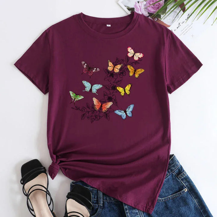 Purple t-shirt with colorful butterfly print, styled with blue jeans and black strappy sandals