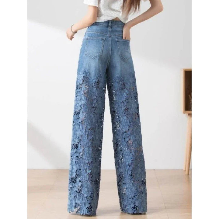 Back view of woman wearing high-waisted blue wide-leg lace denim jeans with floral patterns
