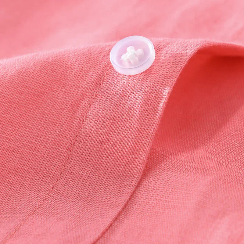 Close-up of pink fabric with a white plastic button sewn on it