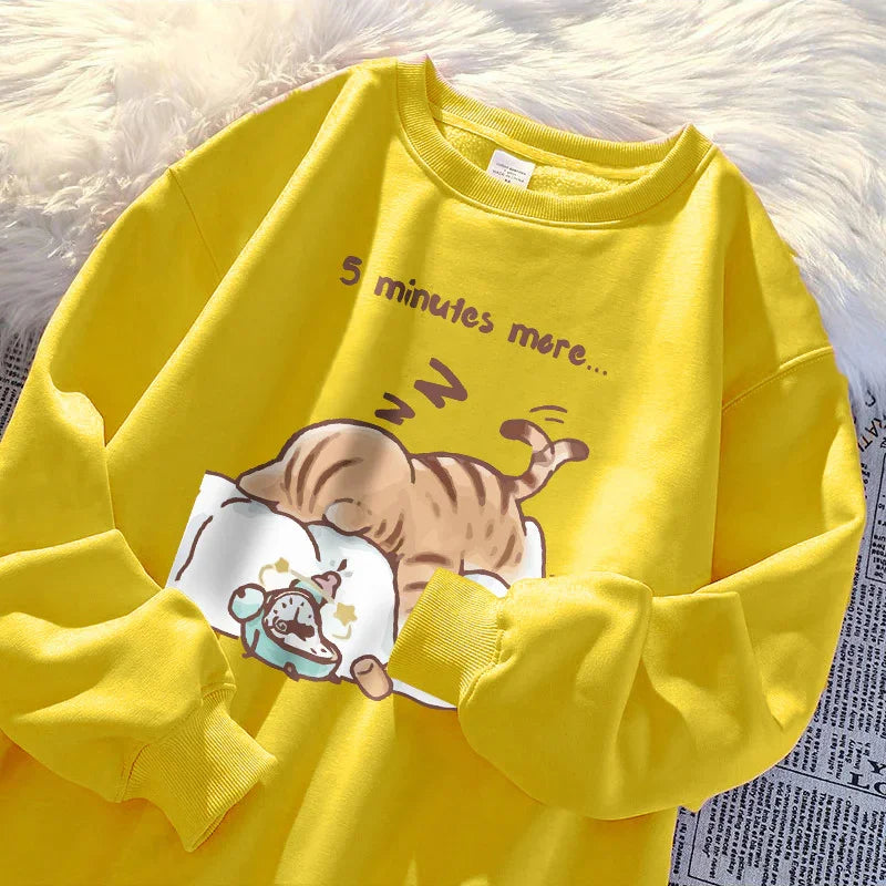 Yellow sweatshirt with cartoon cat sleeping on a pillow and text reading '5 minutes more'