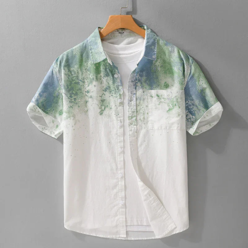 Men's short sleeve button-up shirt with green and blue watercolor print over white fabric