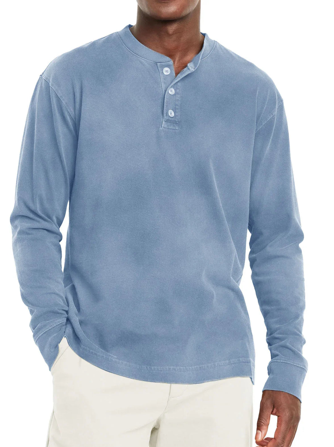 Man wearing a light blue long-sleeve henley shirt with button placket and beige pants