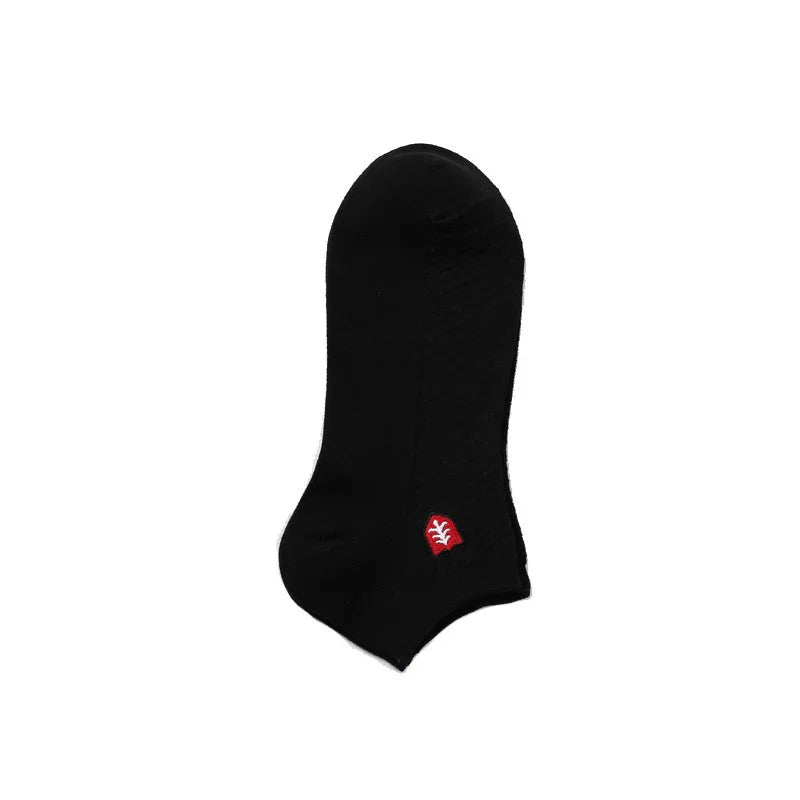 Black ankle sock with small red and white embroidered leaf logo on white background