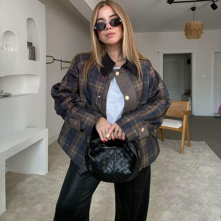 Stylish woman in checkered jacket, black leather pants, sunglasses holding black woven handbag indoors