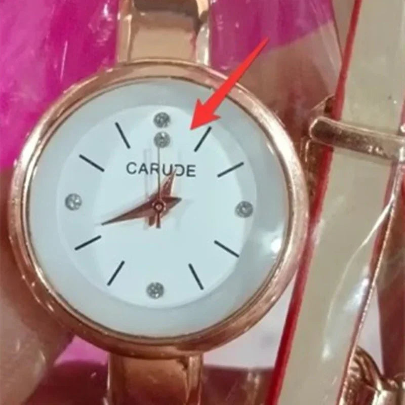 Close-up of a rose gold Carude wristwatch with a white dial, crystal accents, and leather strap