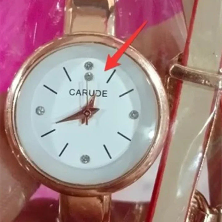 Close-up of a rose gold Carude wristwatch with a white dial, crystal accents, and leather strap