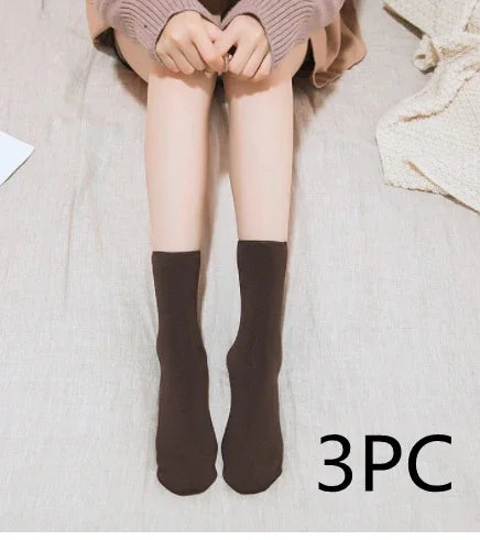 Person wearing cozy brown socks sitting on a light fabric surface with 3PC text
