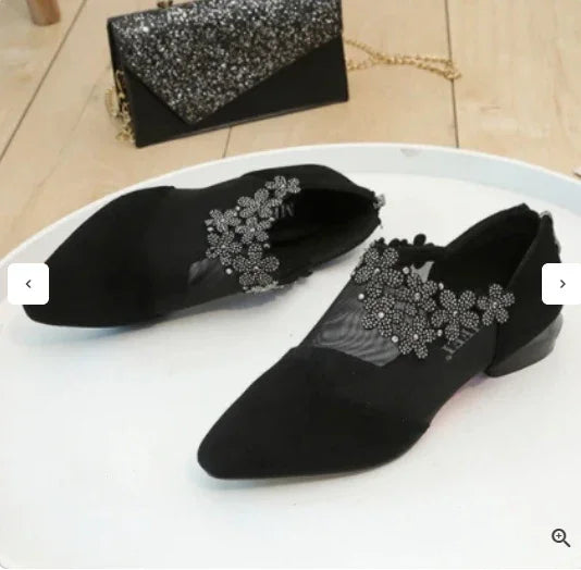 Black pointed toe flats with floral rhinestone embellishments and a black glitter clutch with gold chain