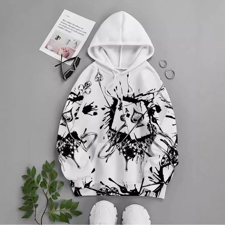 White hoodie with black graffiti-style abstract print, playing cards, and poker chips on gray background
