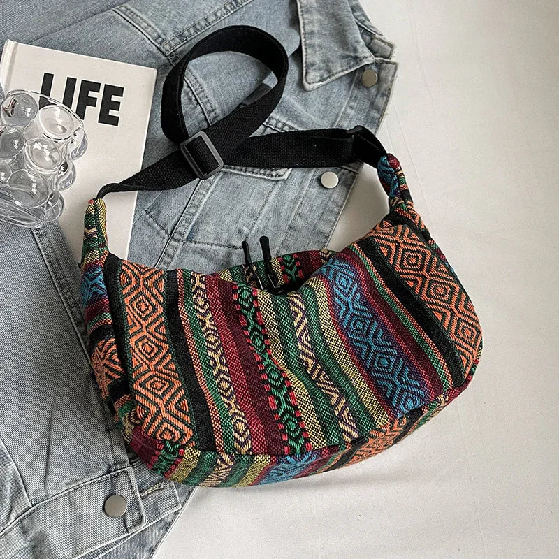 Colorful woven fabric crossbody bag with geometric patterns on denim jacket and LIFE book