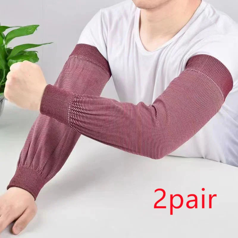 Person wearing maroon striped compression arm sleeves on white table with green plant background