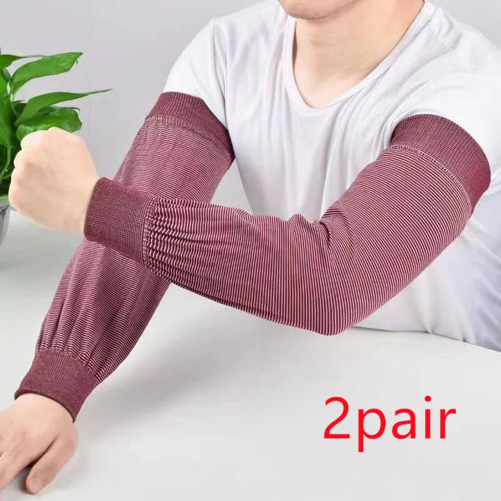 Person wearing maroon striped compression arm sleeves on white table with green plant background