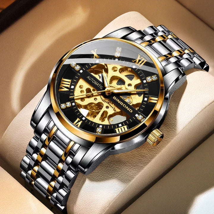 Luxury men's automatic skeleton watch with gold and silver stainless steel band on beige cushion