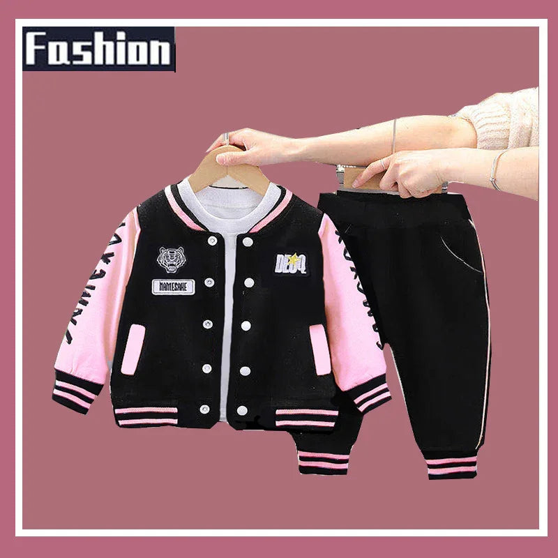 Kids fashion set featuring black and pink varsity jacket with patches and matching black pants with pink cuffs