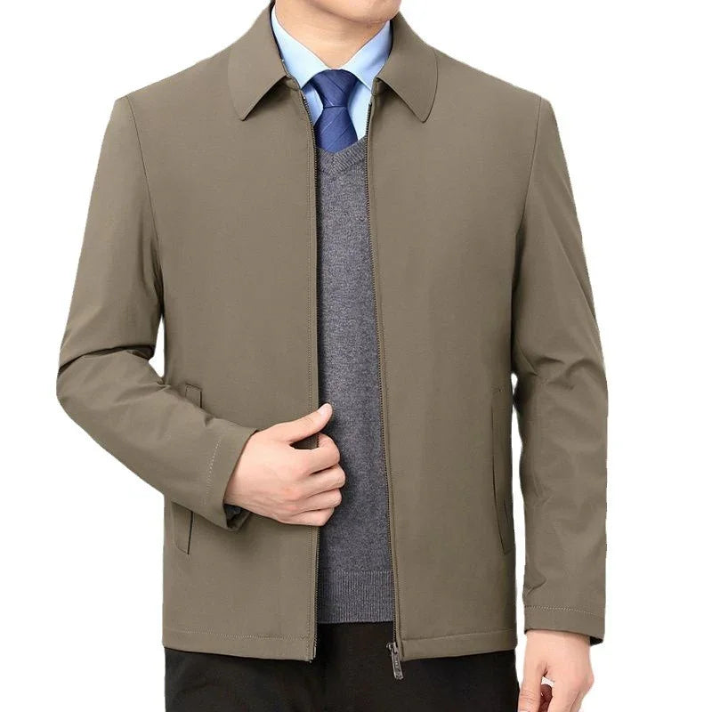 Men's casual brown zip-up jacket worn over gray sweater and blue shirt with tie