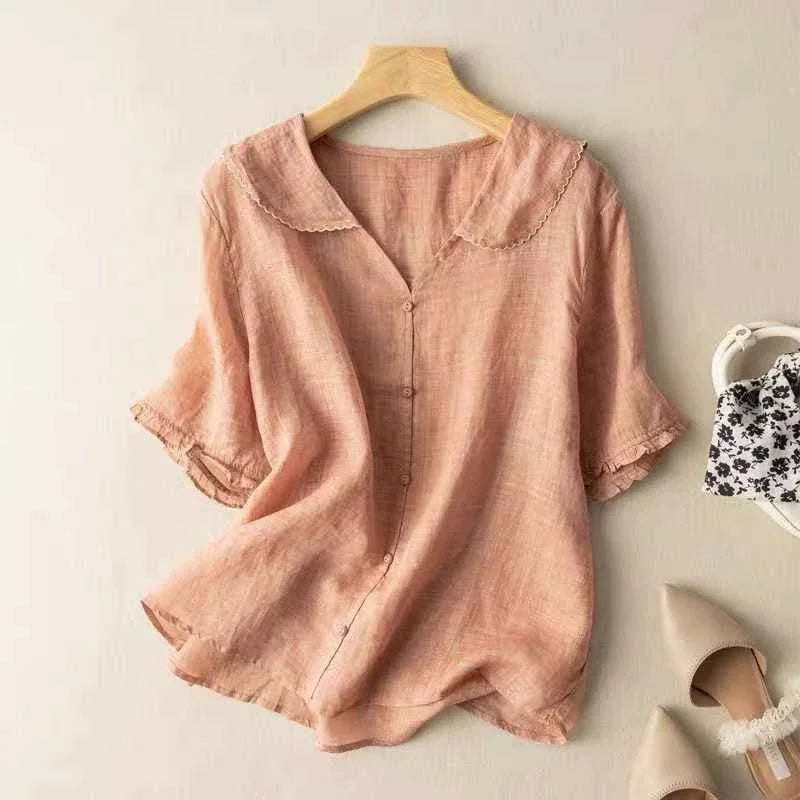 Light pink linen blouse with scalloped collar and button front, paired with beige pointed flats and floral bag