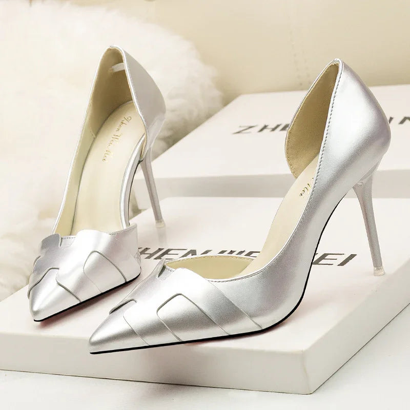 Pair of silver metallic high heel pointed toe women's shoes on white branded boxes