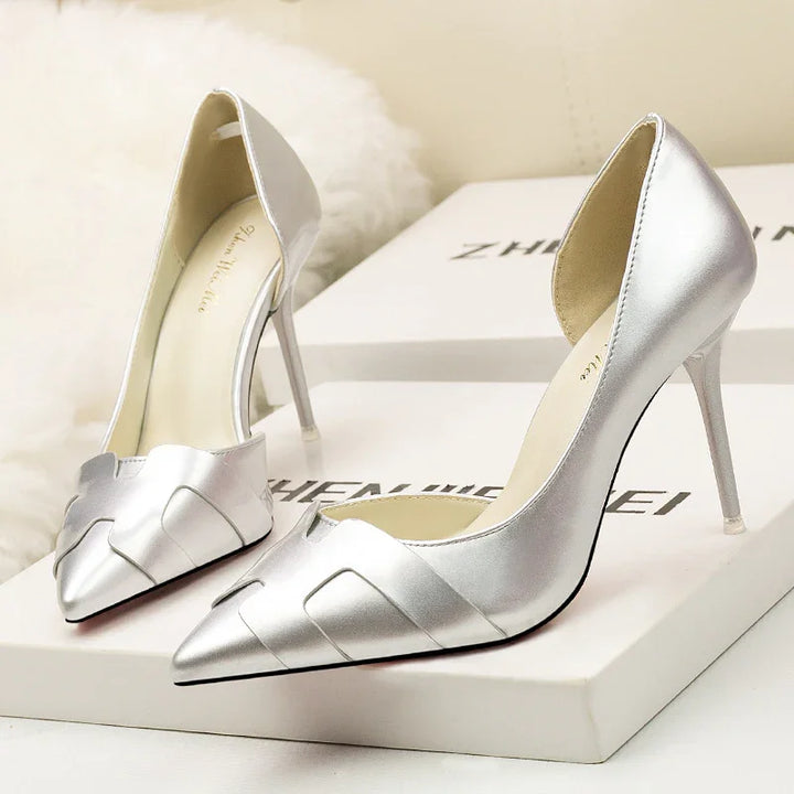 Pair of silver metallic high heel pointed toe women's shoes on white branded boxes