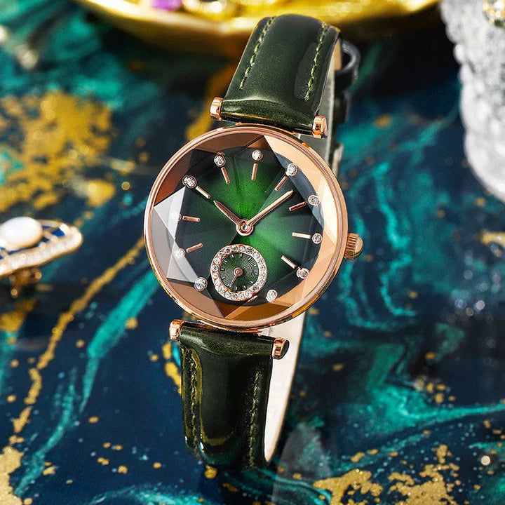 Elegant green wristwatch with rose gold case and crystal accents on luxurious green marble surface