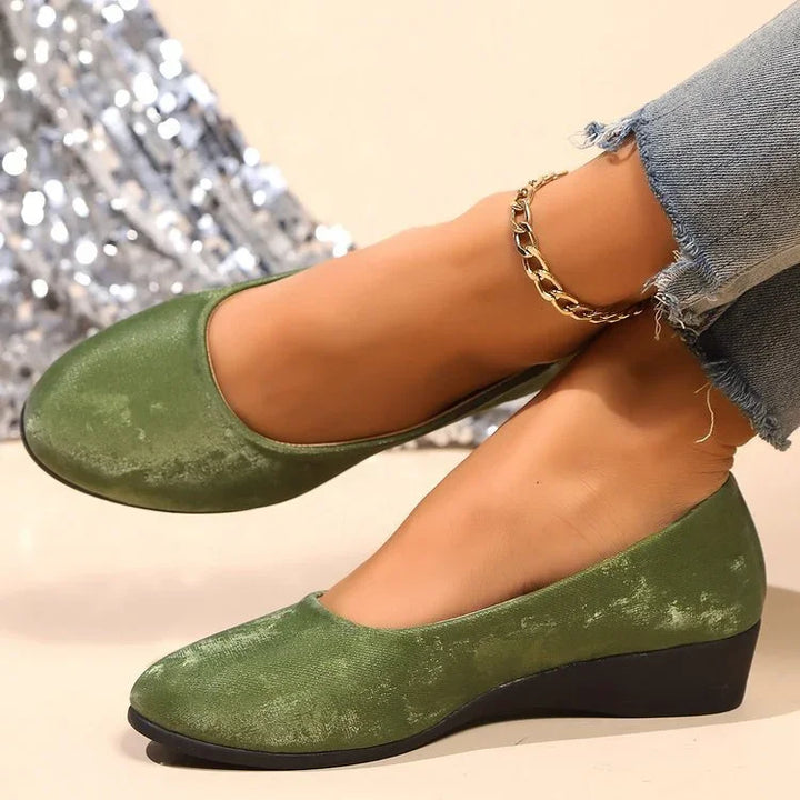 Green velvet wedge shoes worn with frayed hem jeans and a gold chain anklet