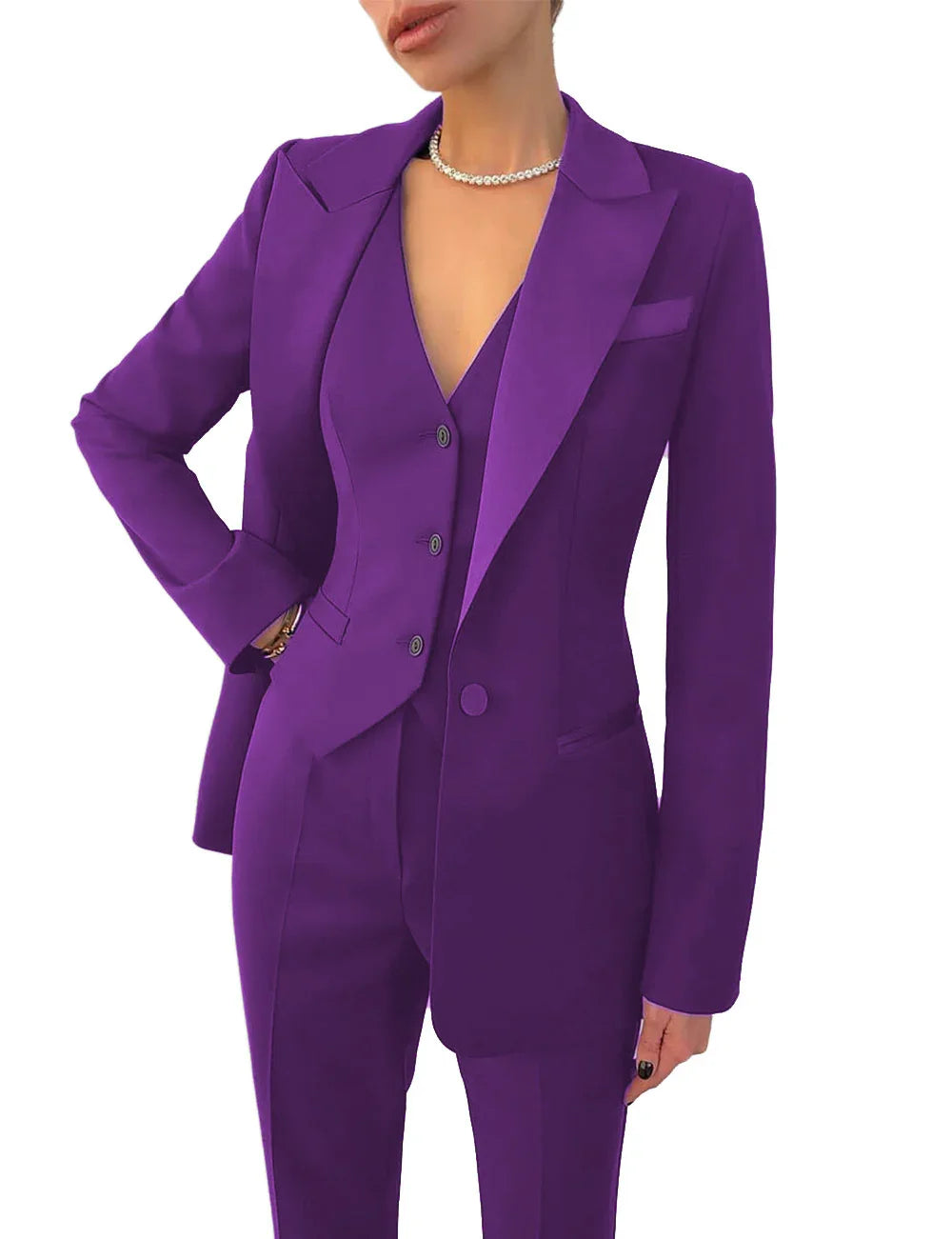 Woman wearing a tailored purple pantsuit with blazer and vest, accessorized with pearl necklace