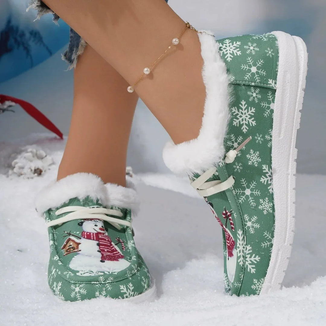 Green winter slippers with snowman and snowflake design, white fur lining, worn with pearl anklet
