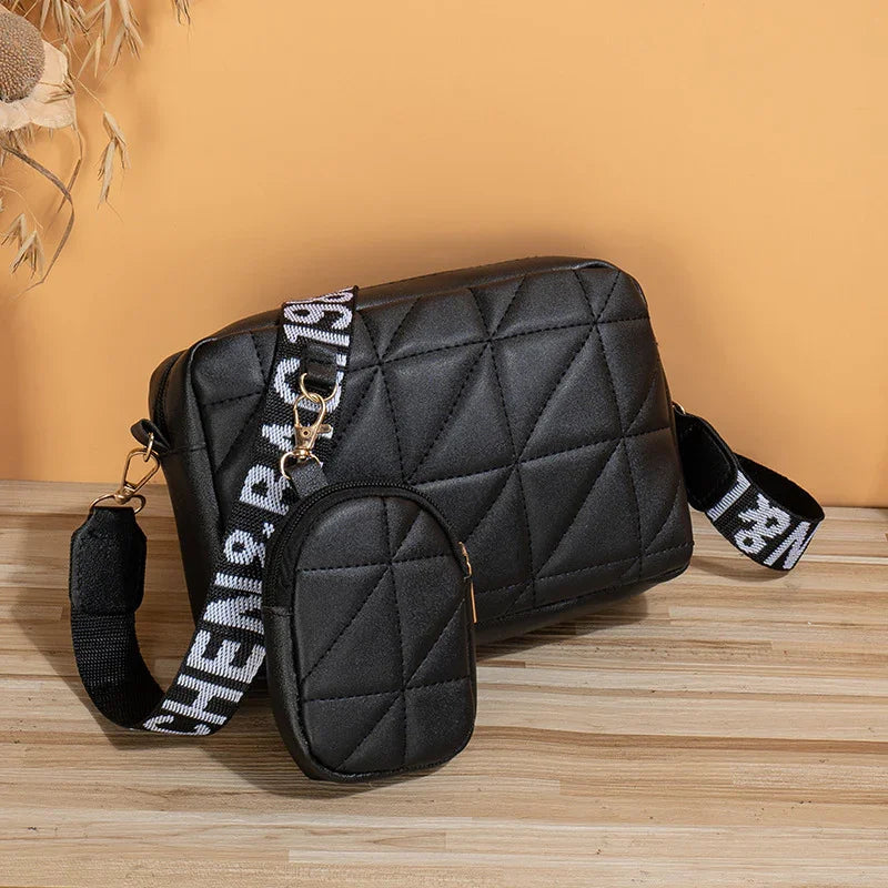 Black quilted crossbody bag with matching small pouch and black-and-white adjustable strap