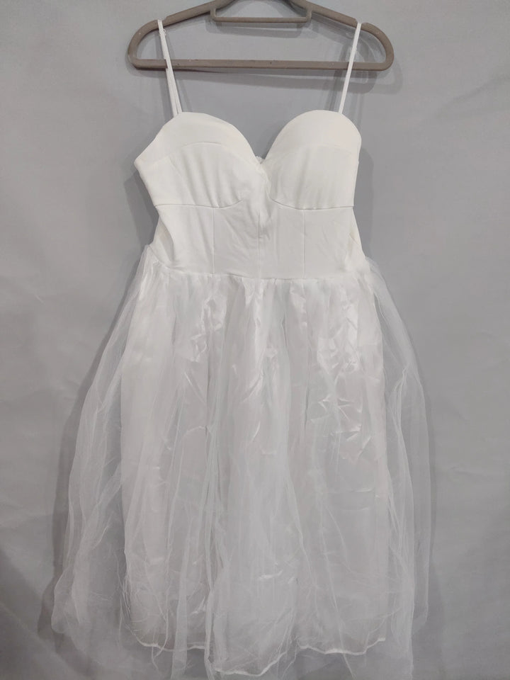 White strapless dress with sweetheart neckline and tulle skirt hanging on beige hanger