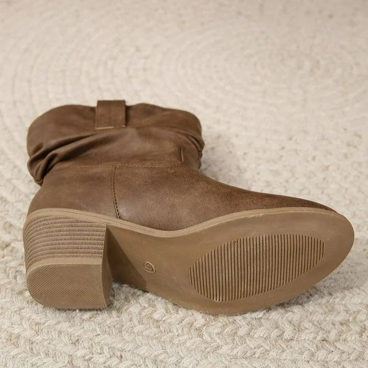 brown suede slouchy ankle boot with block heel on textured beige carpet