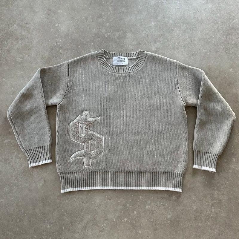 Gray knit crewneck sweater with ribbed cuffs and hem, featuring a textured logo on the front