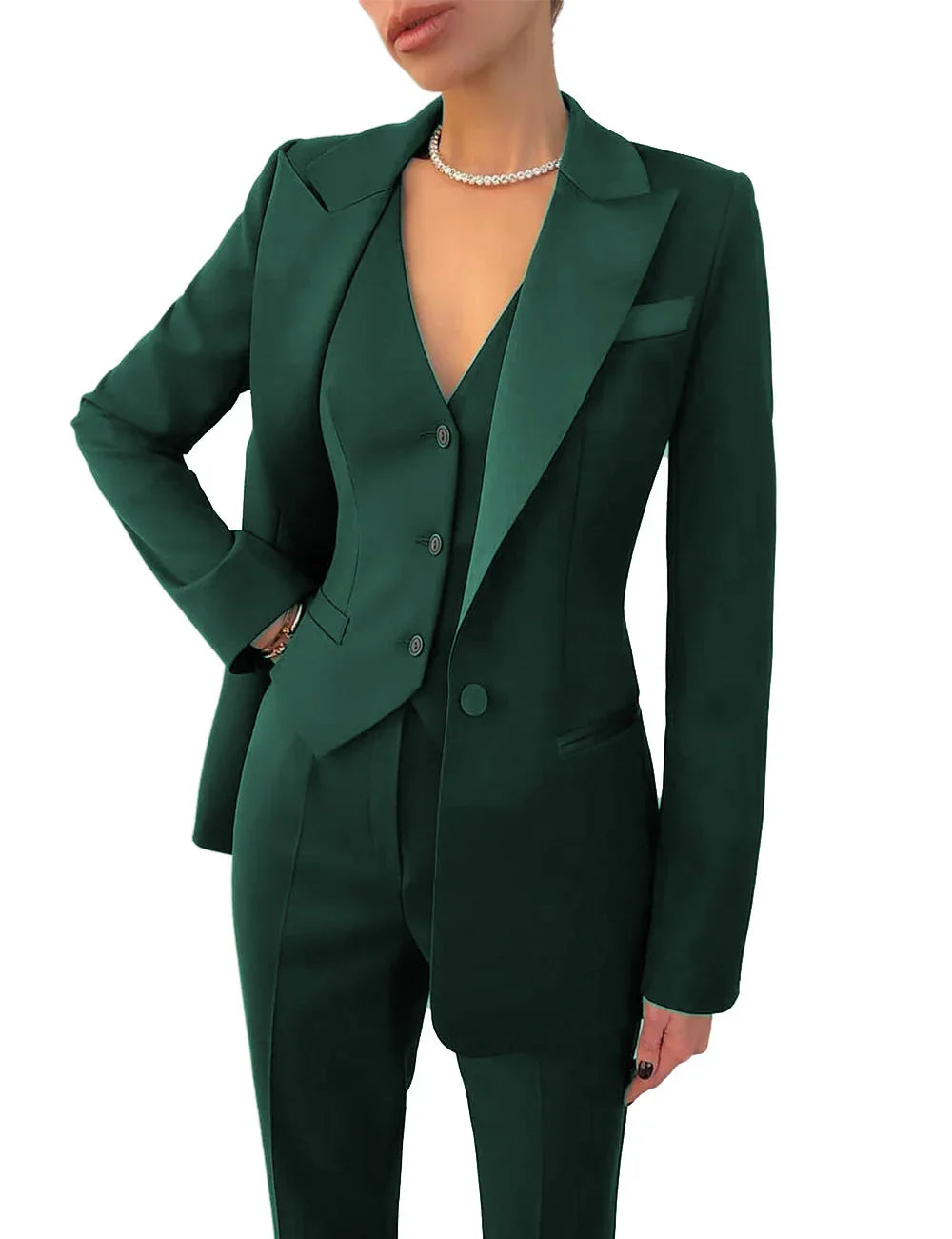 Woman wearing an emerald green tailored three-piece suit with blazer, vest, and pants, accessorized with a pearl necklace