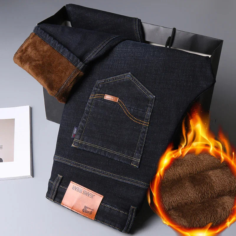 Dark blue denim jeans with warm brown fleece lining, folded with fire graphic showing insulation