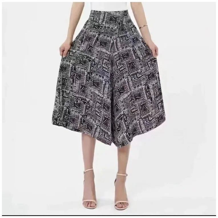 Woman wearing high-waisted black and white abstract print wide-leg culottes with ankle-strap heels