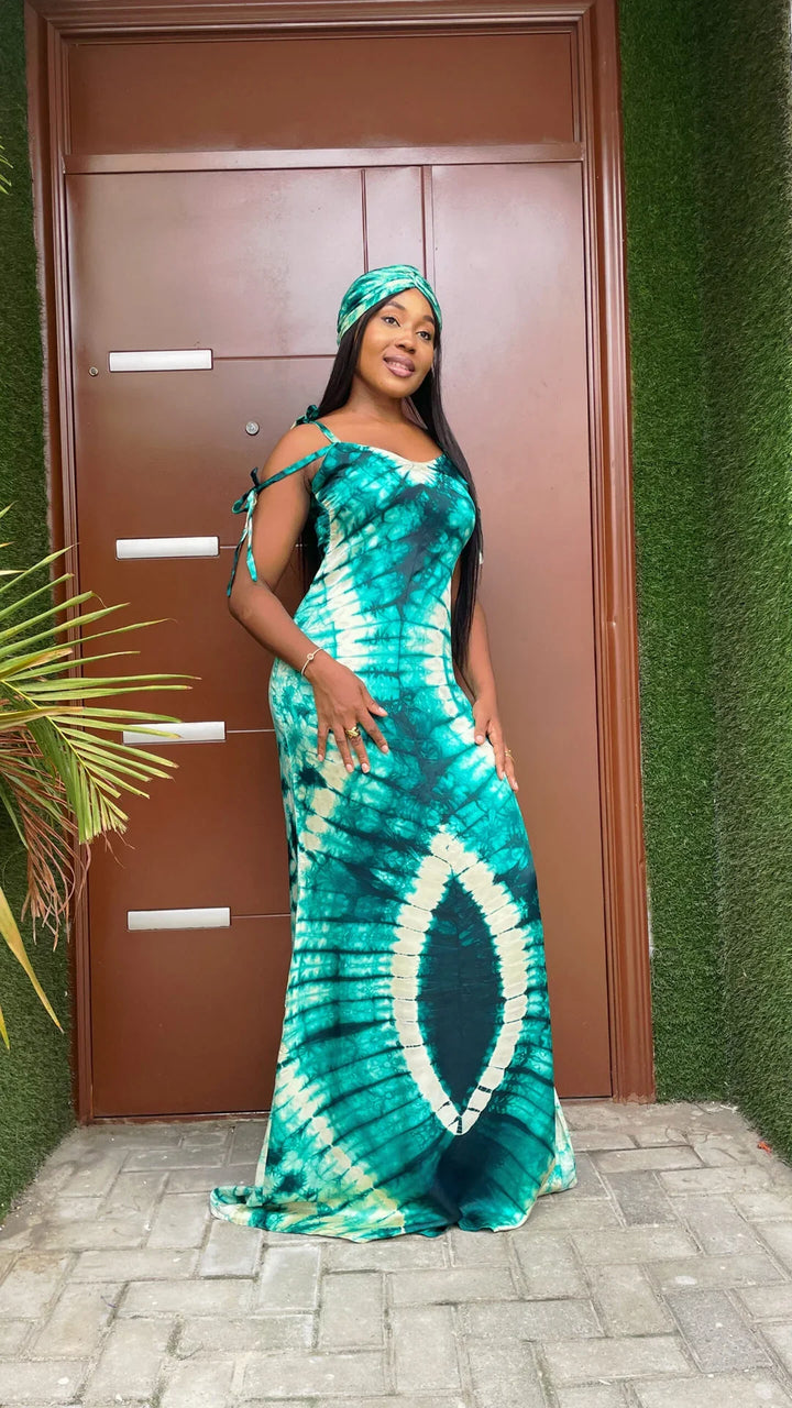 Woman wearing teal and white tie-dye sleeveless maxi dress and matching headwrap standing outdoors