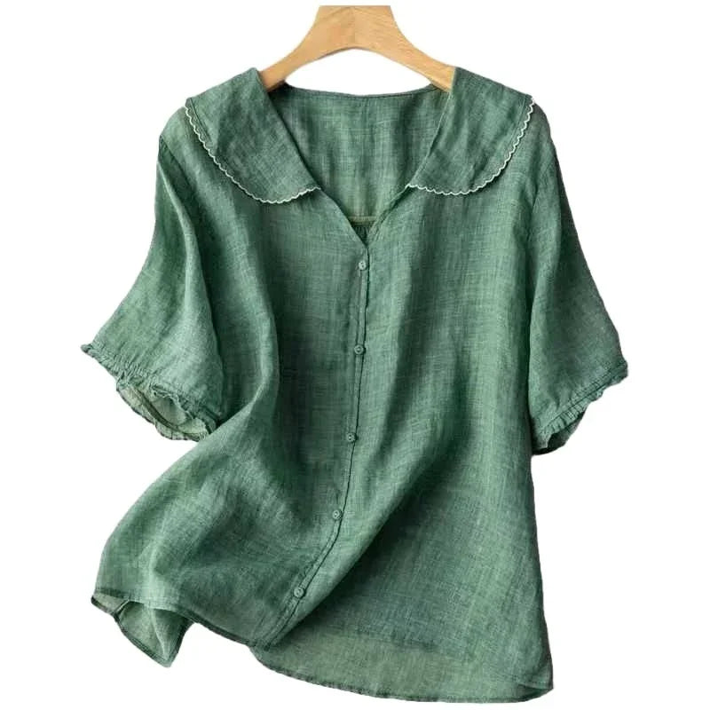 Green linen button-up blouse with short puff sleeves and scalloped collar on wooden hanger
