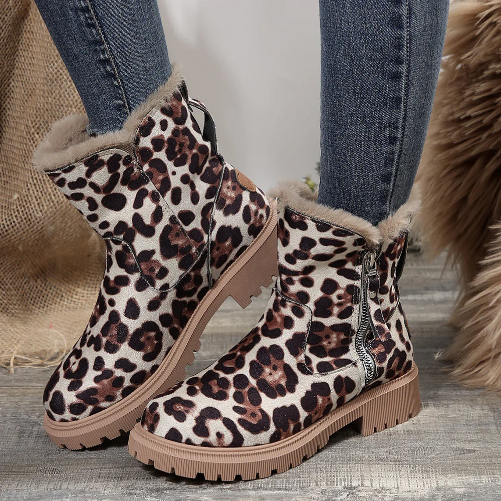 Leopard print winter boots with fur lining and side zipper worn with skinny jeans on wooden floor