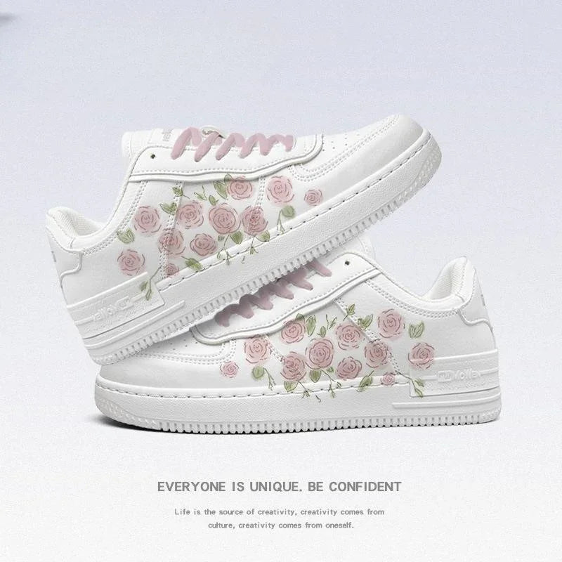 White sneakers with pink rose floral design and matching pink laces on a light background