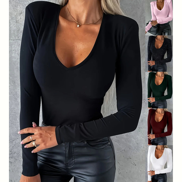 Woman wearing long-sleeve V-neck slim fit top in black, styled with black leather pants and gold necklace