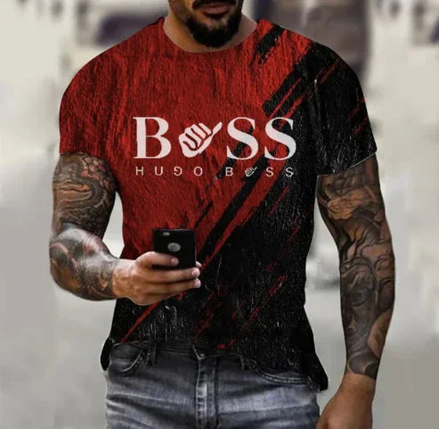 Man wearing red and black Hugo Boss T-shirt with bold logo, holding smartphone, tattooed arms visible