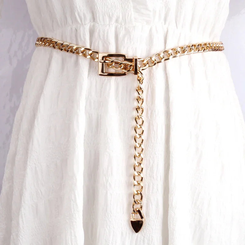 Gold chain belt with rectangular buckle on white textured dress