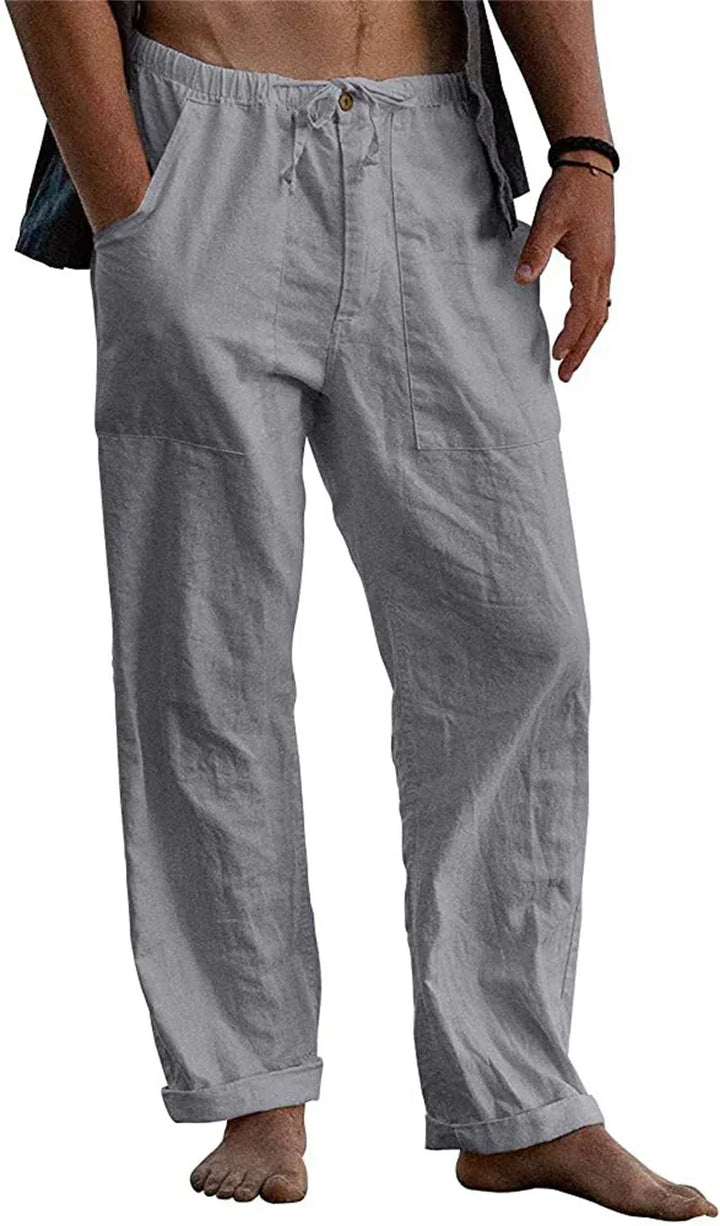 Men's casual light gray linen pants with drawstring waist and rolled cuffs, barefoot model