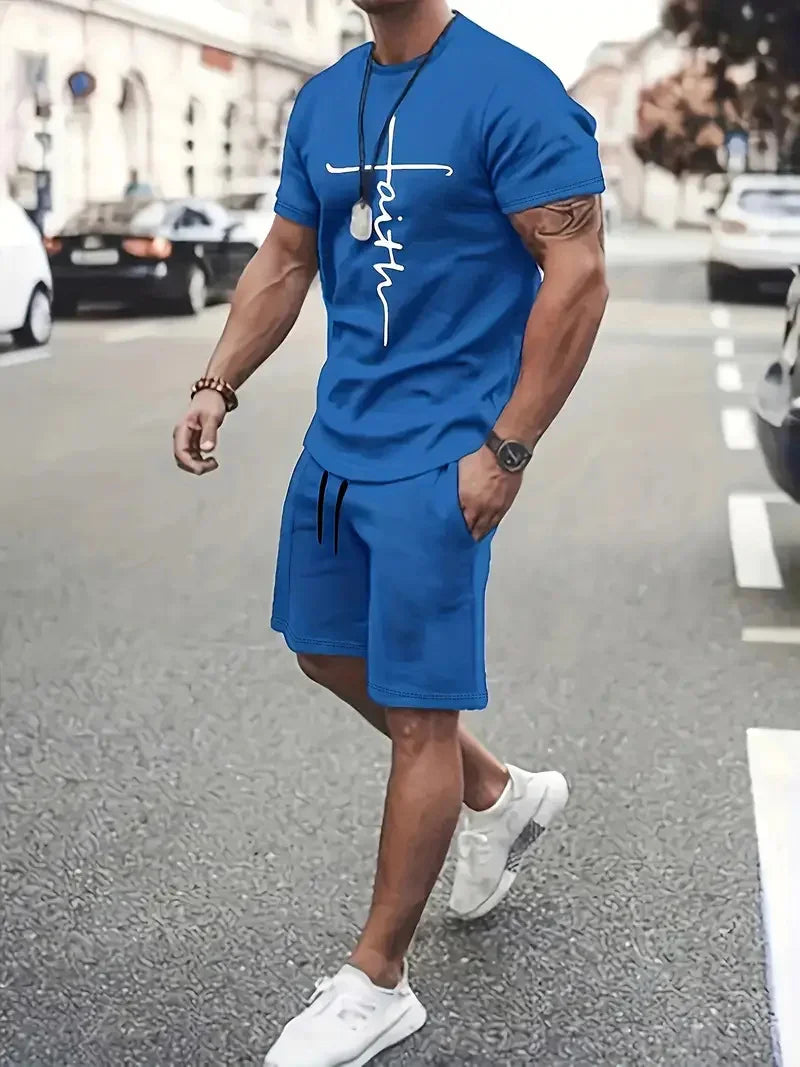 Man wearing blue faith print t-shirt and matching shorts walking on city street in white sneakers