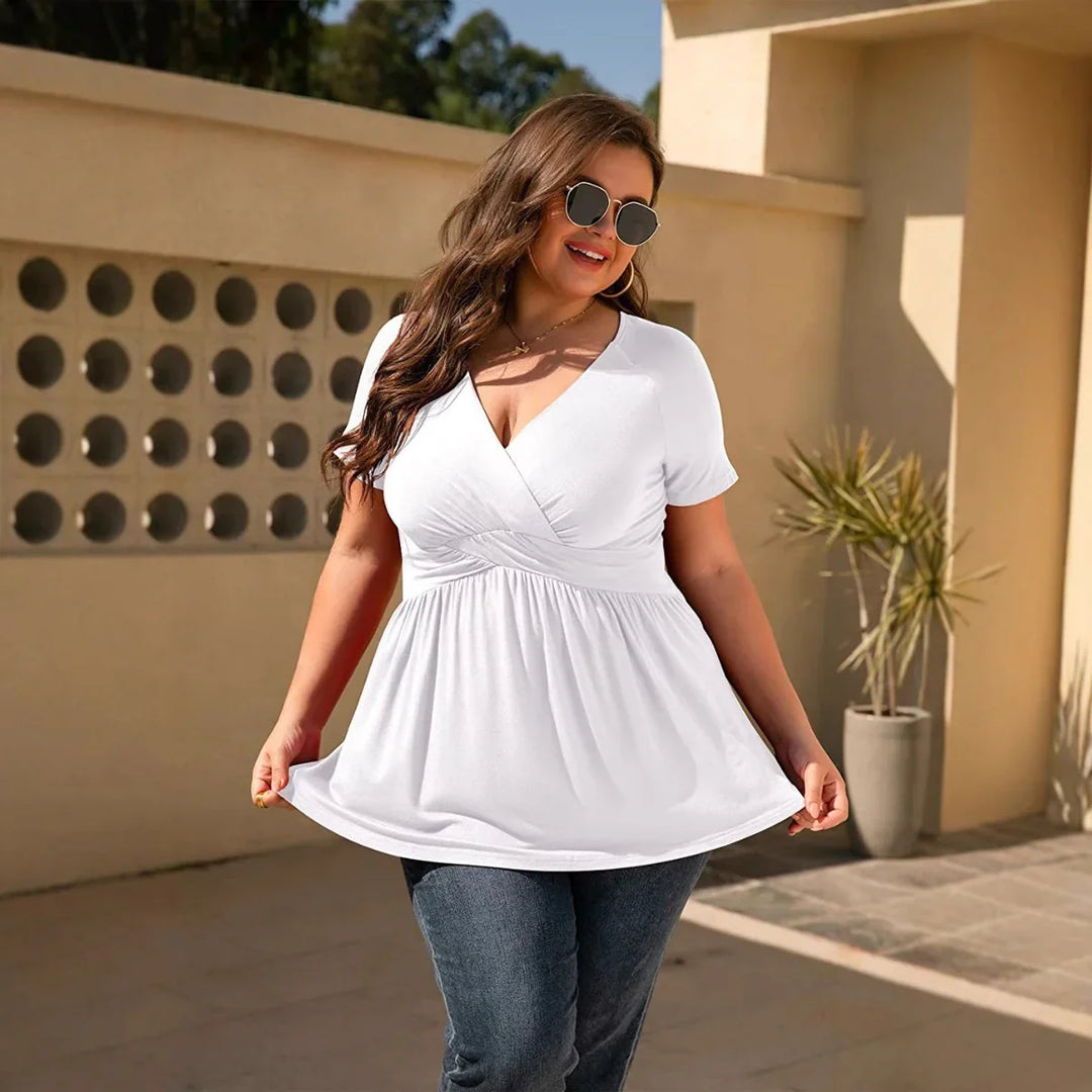 Plus size woman wearing white short sleeve V-neck top and sunglasses outdoors