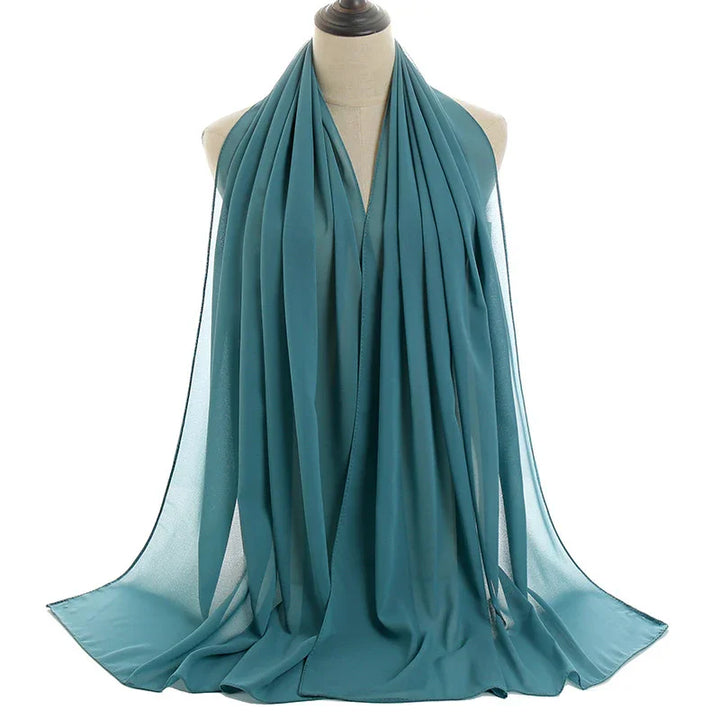 Teal chiffon scarf draped elegantly on a dress form mannequin against white background