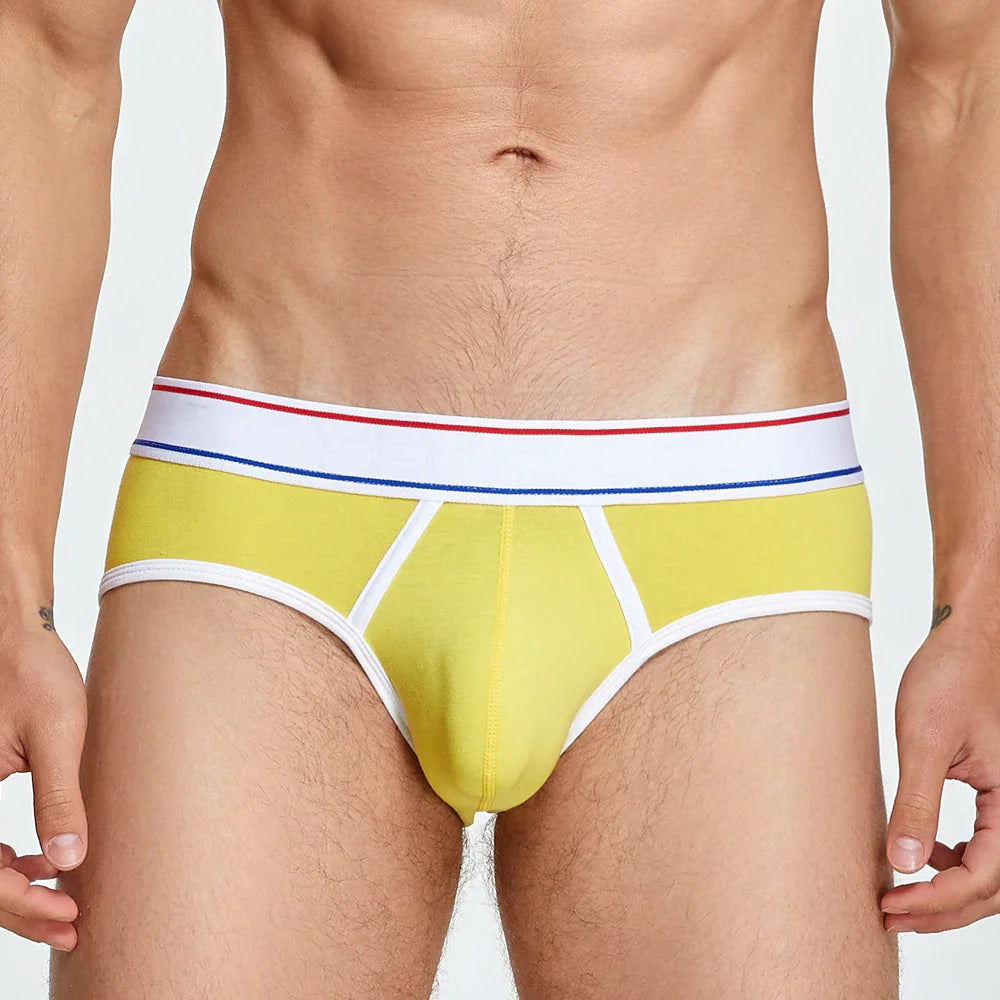 close-up of man's torso wearing yellow cotton briefs with white waistband featuring red and blue stripes