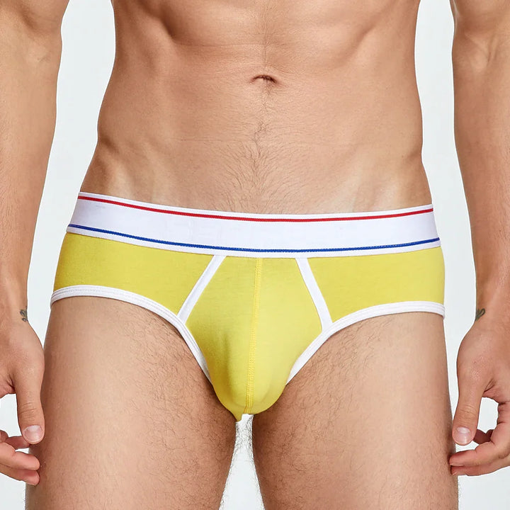close-up of man's torso wearing yellow cotton briefs with white waistband featuring red and blue stripes
