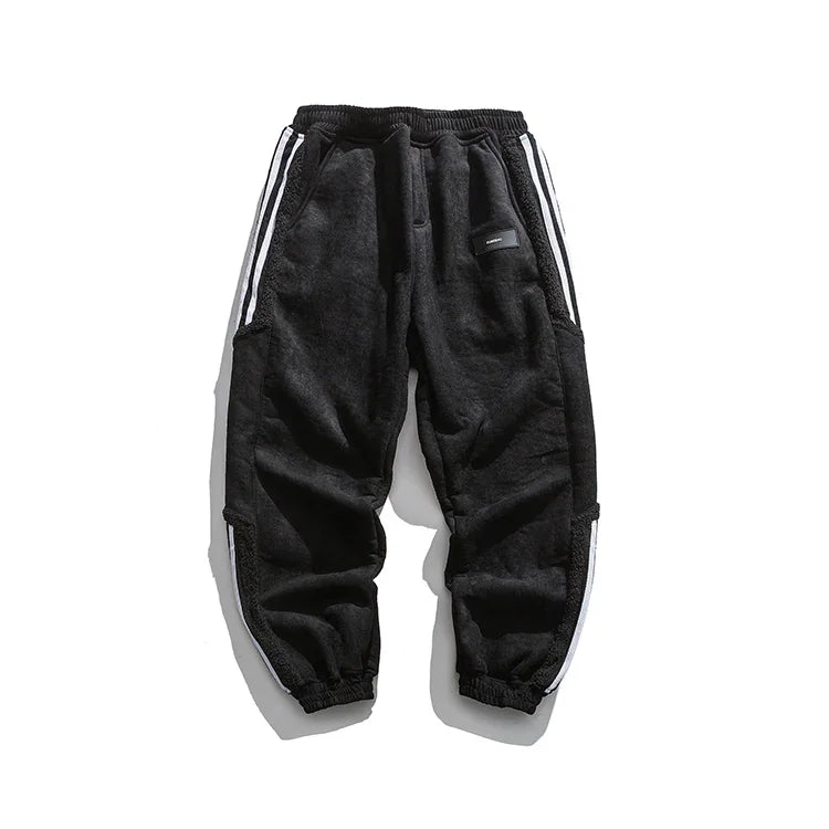 Black fleece jogger pants with white side stripes and elastic waist and cuffs, isolated on white