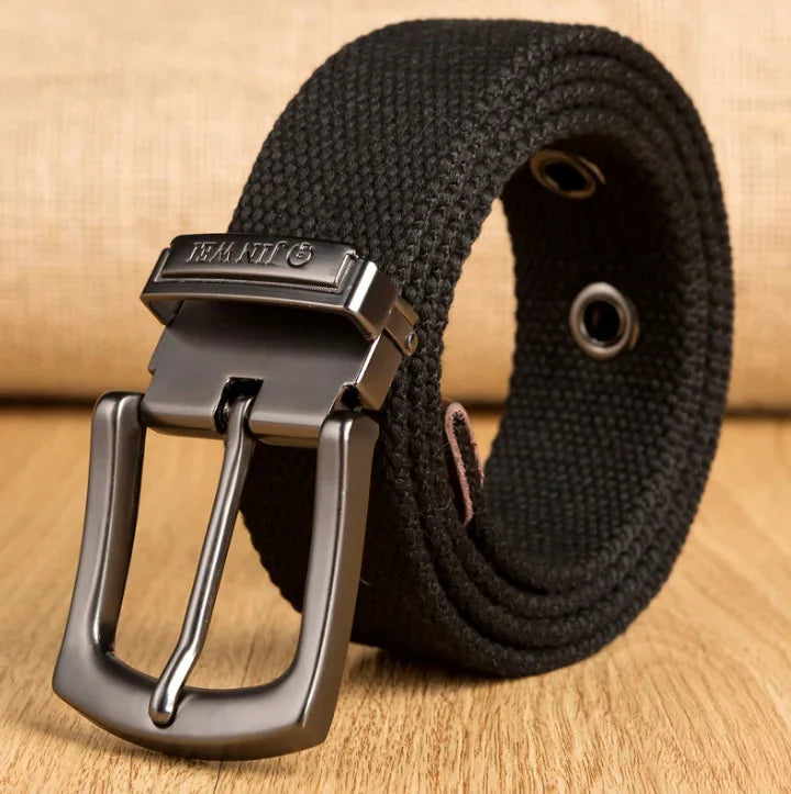 Black woven fabric belt with metal buckle on wooden surface