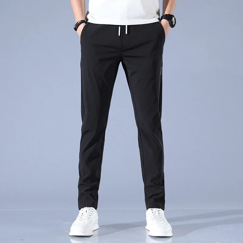 Front view of man wearing black slim fit pants with white drawstrings and white sneakers