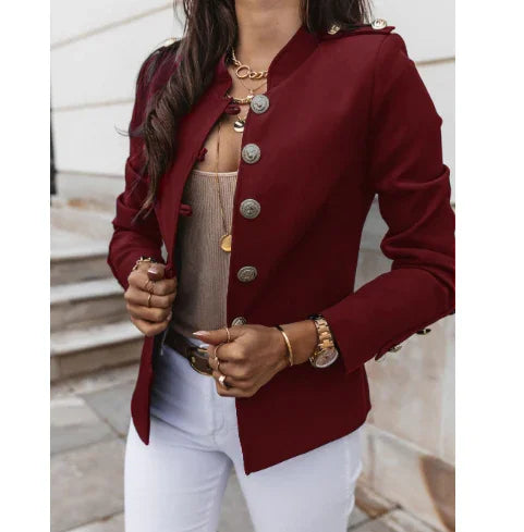 woman wearing stylish burgundy military-style blazer with silver buttons and white pants outdoors